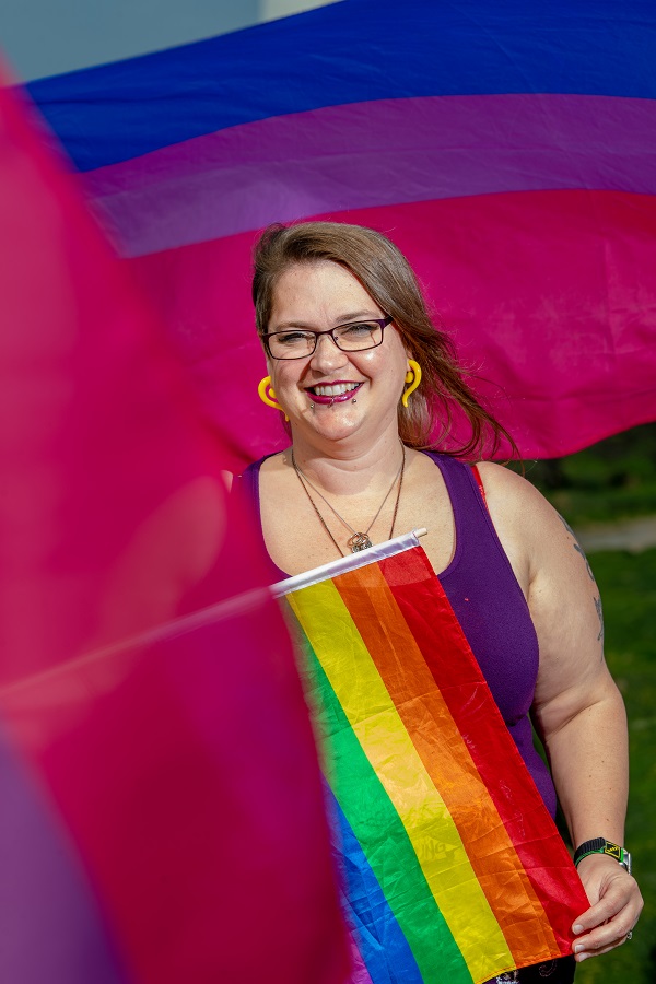 WI Member Vicky holding a rainbow Pride flag
