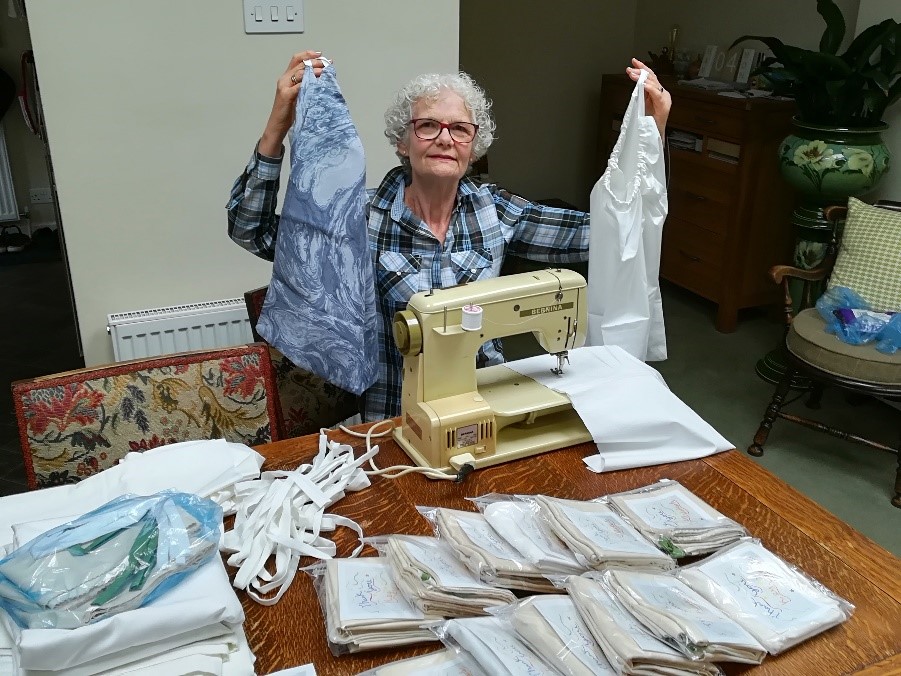 A woman holding up two handmade scrub bags