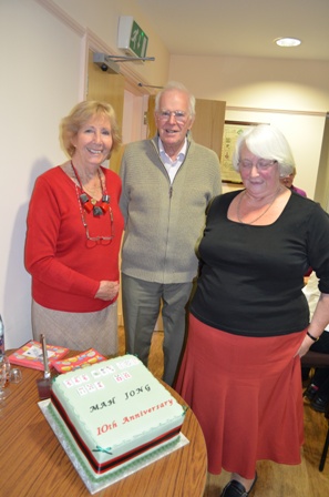 Photo shows Shirley Corke, County Chairman, with her husband Peter Corke and member of Mahjong group with the celebratory cake