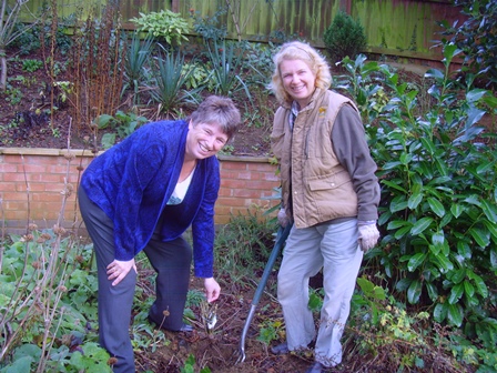 Sue Kendall, County Chairman and Gina Starling, Garden Officer, planting a Centenial Rose in the garden at WI House