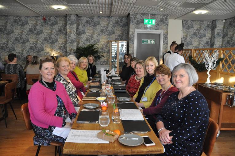 WI members sitting at a long table for lunch
