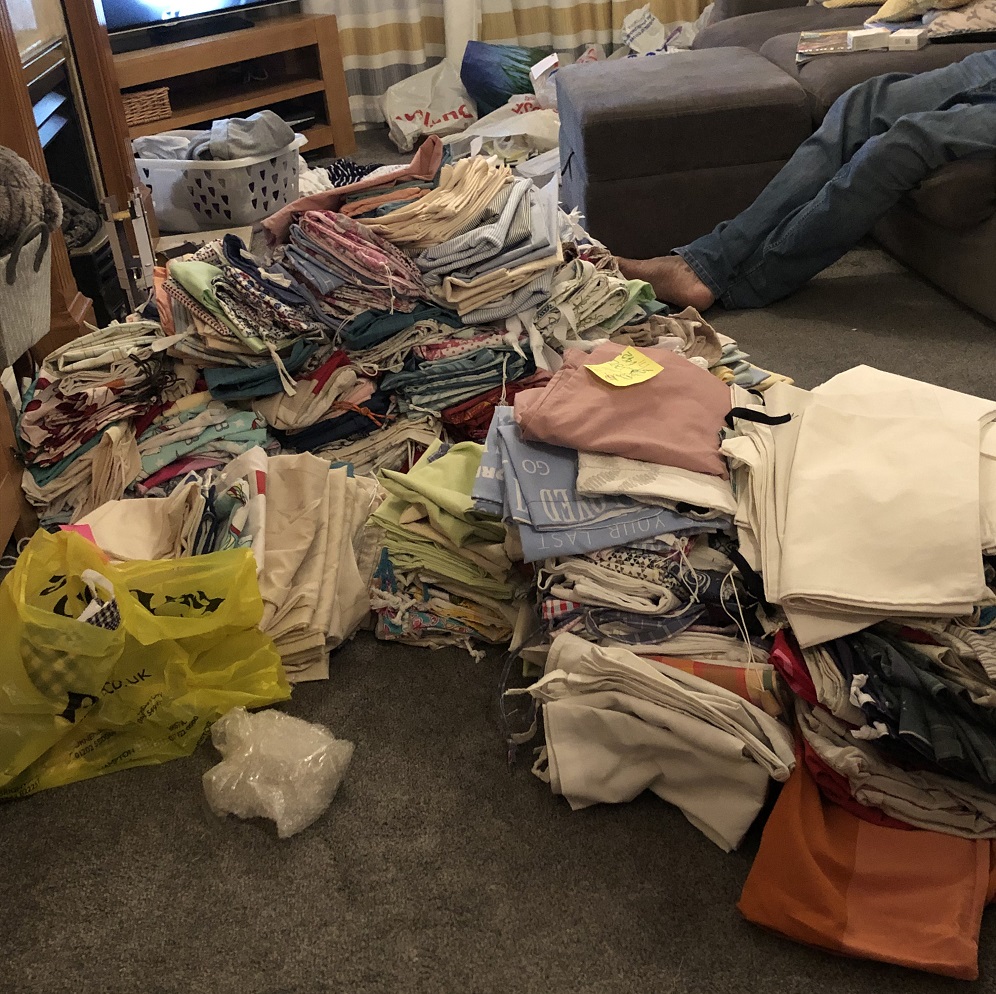 Multiple piles of cloth lying on the floor of a living room