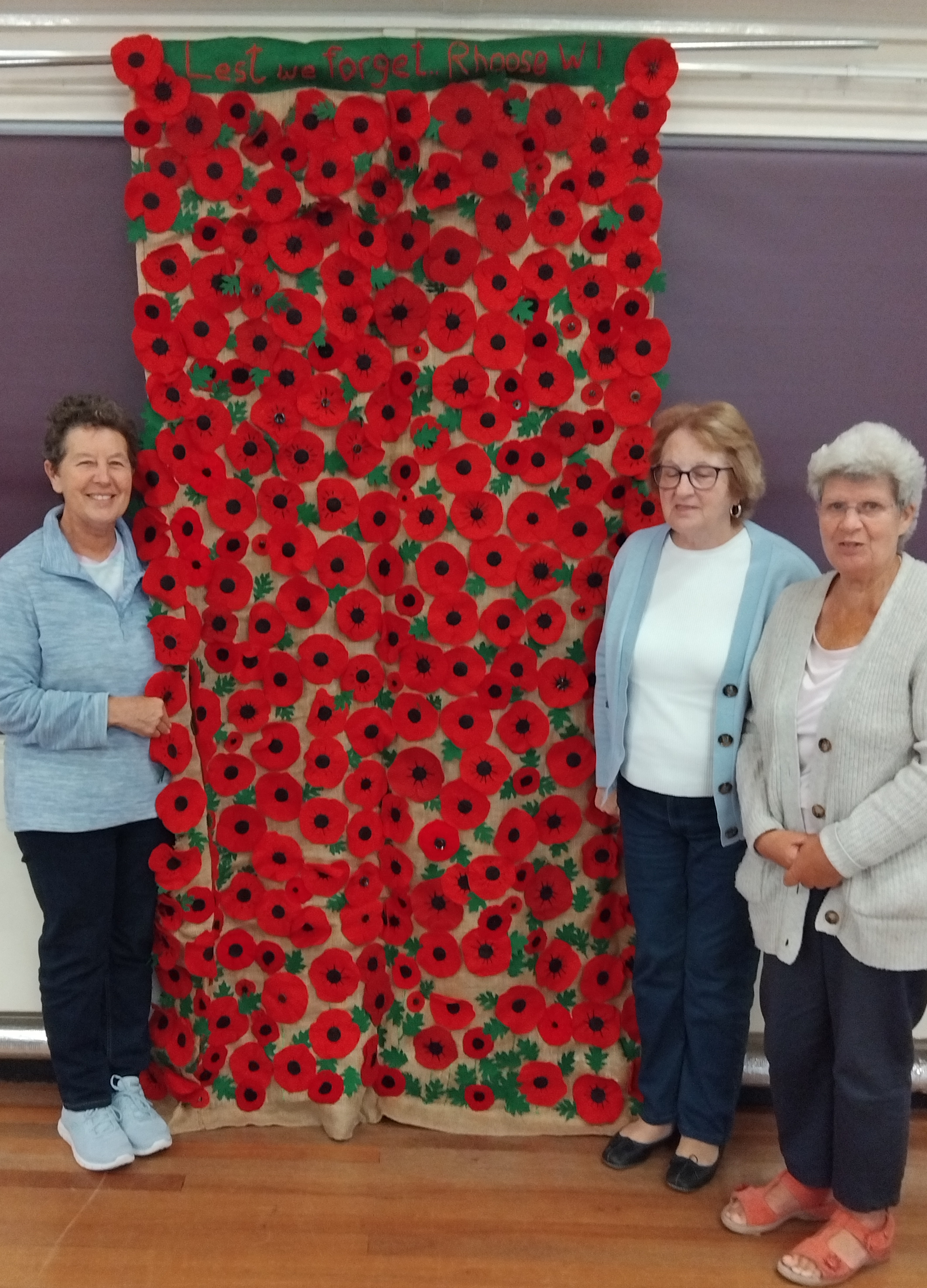 Rhoose WI with 3 members stood by a poppy tapestry
