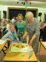 Daphne Cutting the Birthday Cake being watched by our President and Secretary