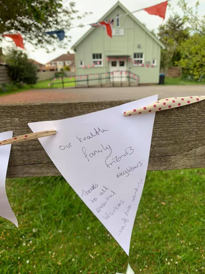 A message written on bunting at a fence