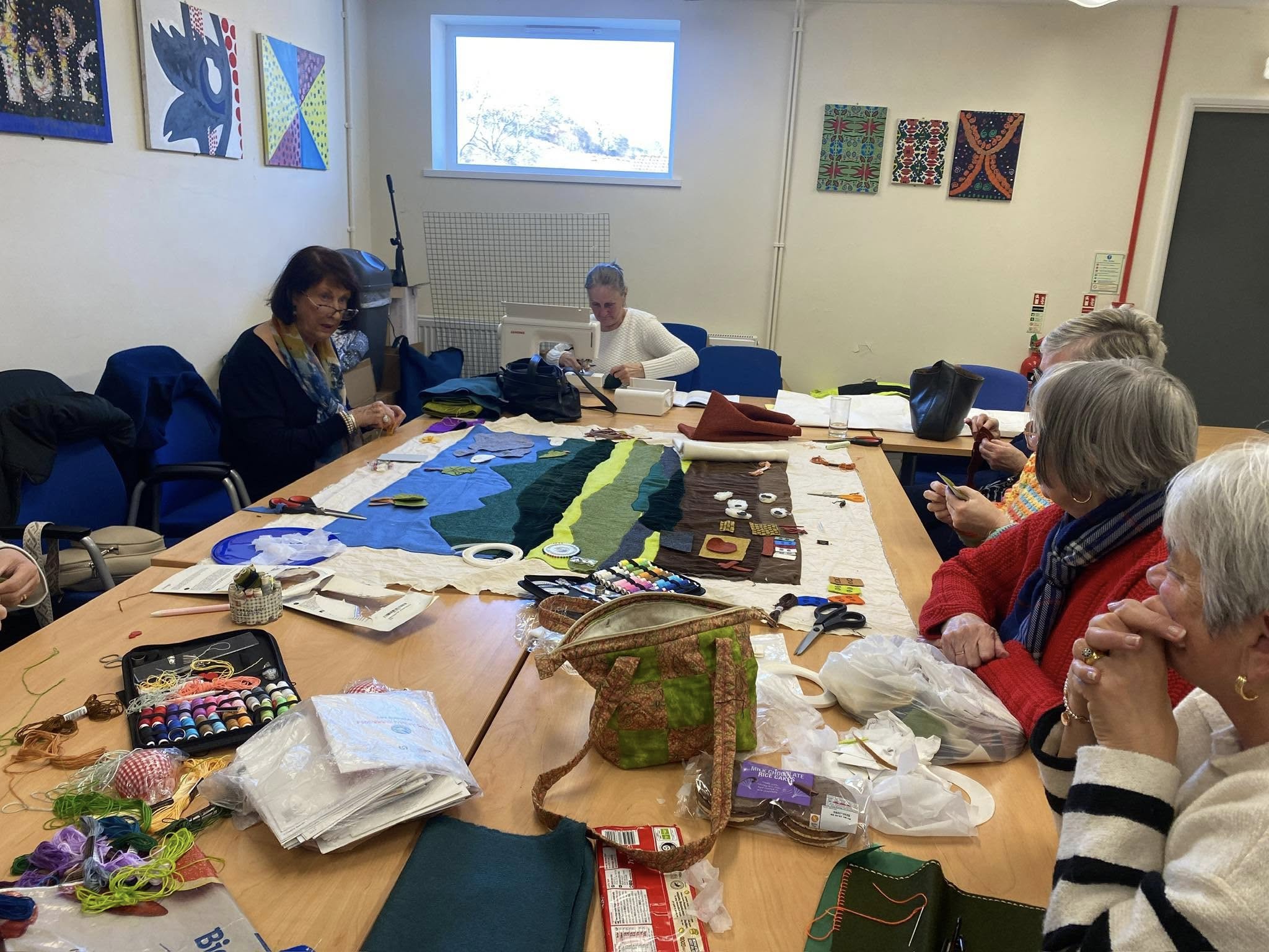 Tom Pentre and Gelli WI with several women sat around a craft table