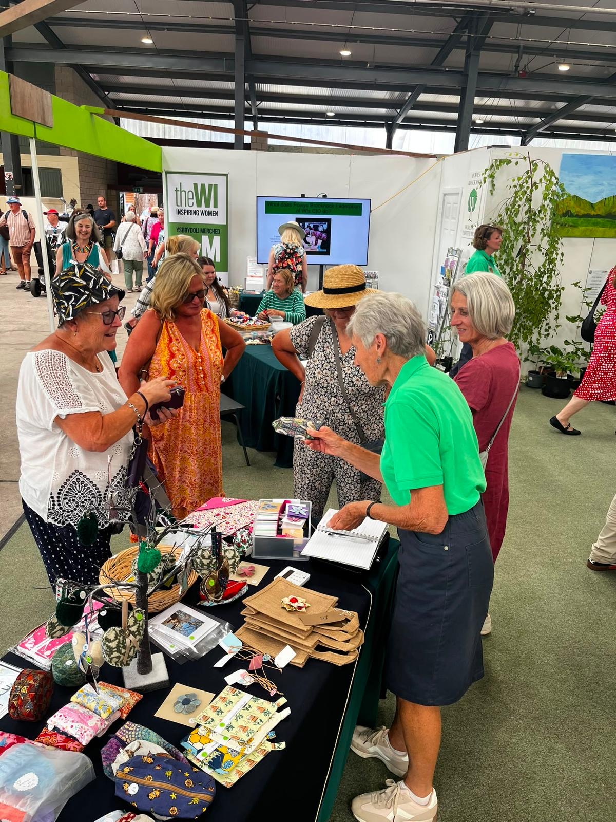 Several women standing around the WI Stand