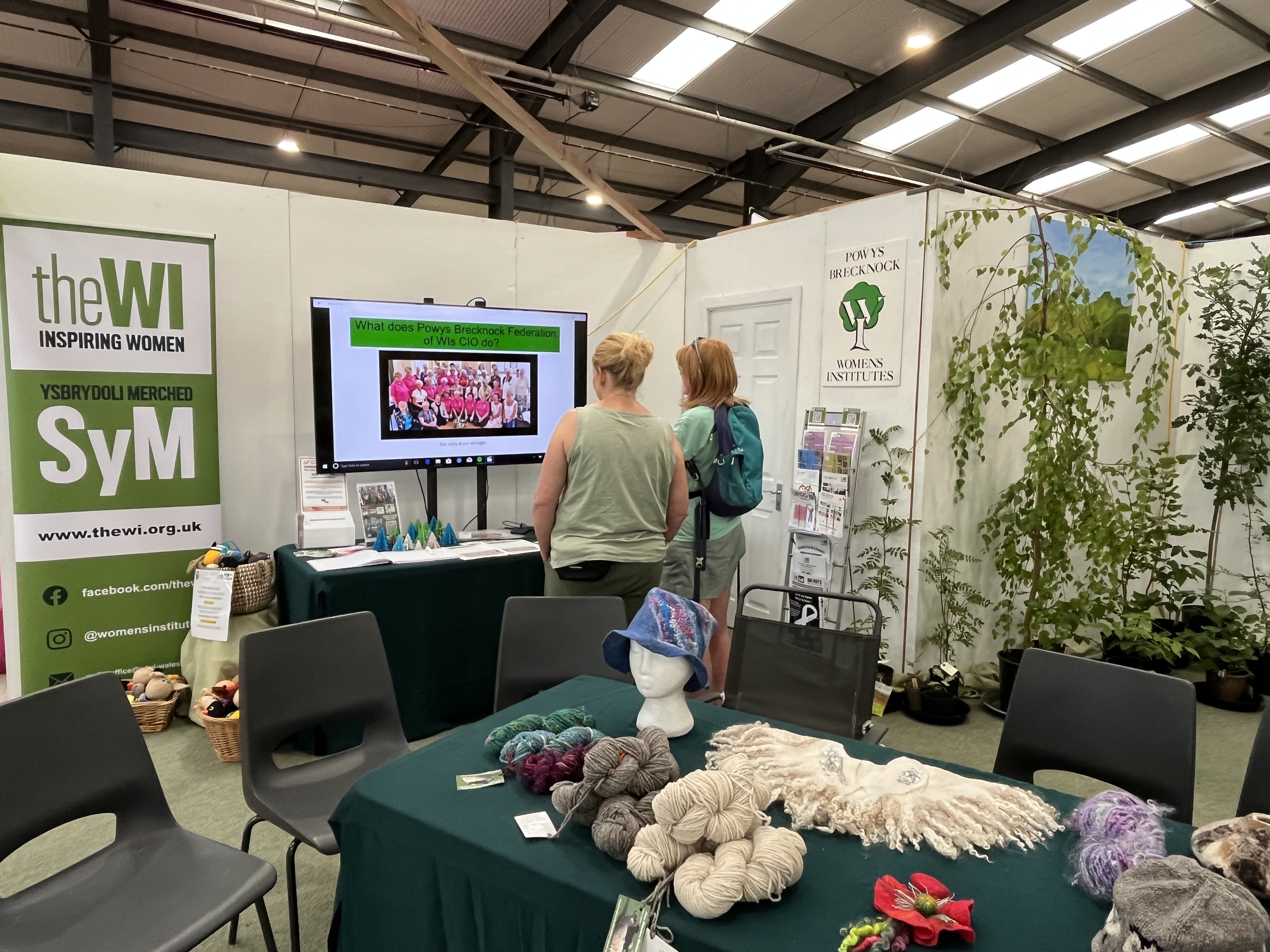 Two women stood by a TV at the WI Stand